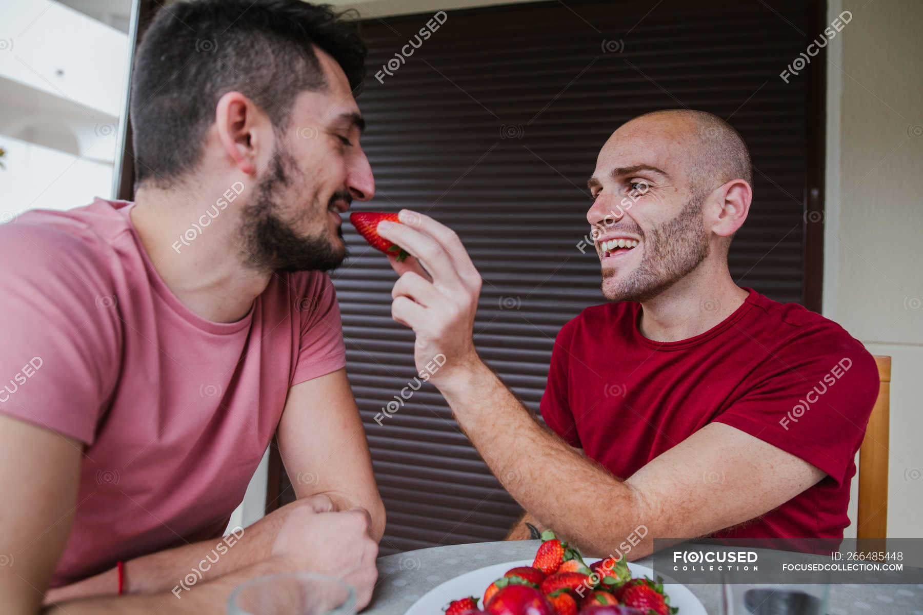 focused_266485448-stock-photo-cheerful-gay-couple-eating-strawberries.jpg